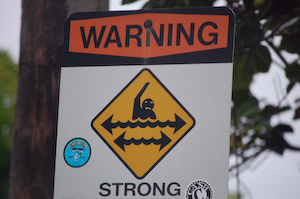 Roadway sign, helpfully enhanced by some creative soul with a few bits of surfwax.